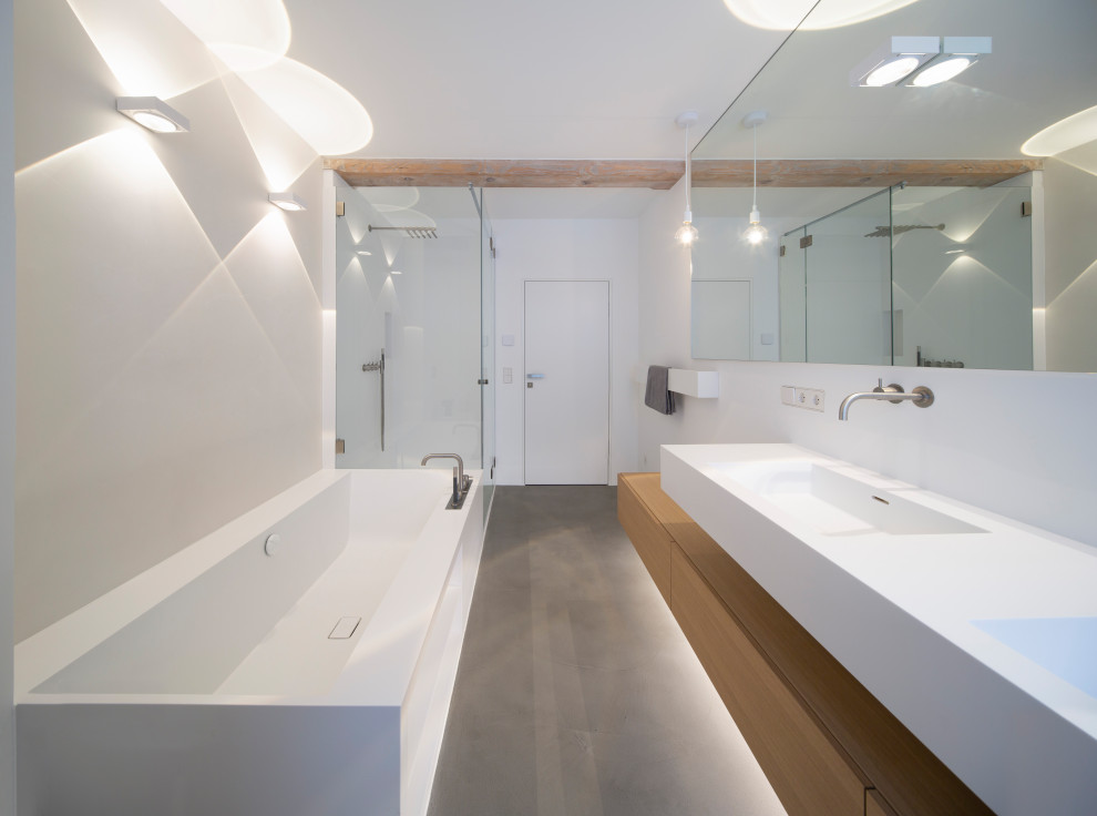 Cette image montre une salle de bain minimaliste en bois brun avec un placard à porte plane, une baignoire posée, une douche à l'italienne, un lavabo intégré, un plan de toilette en surface solide, un plan de toilette blanc, meuble double vasque et meuble-lavabo suspendu.