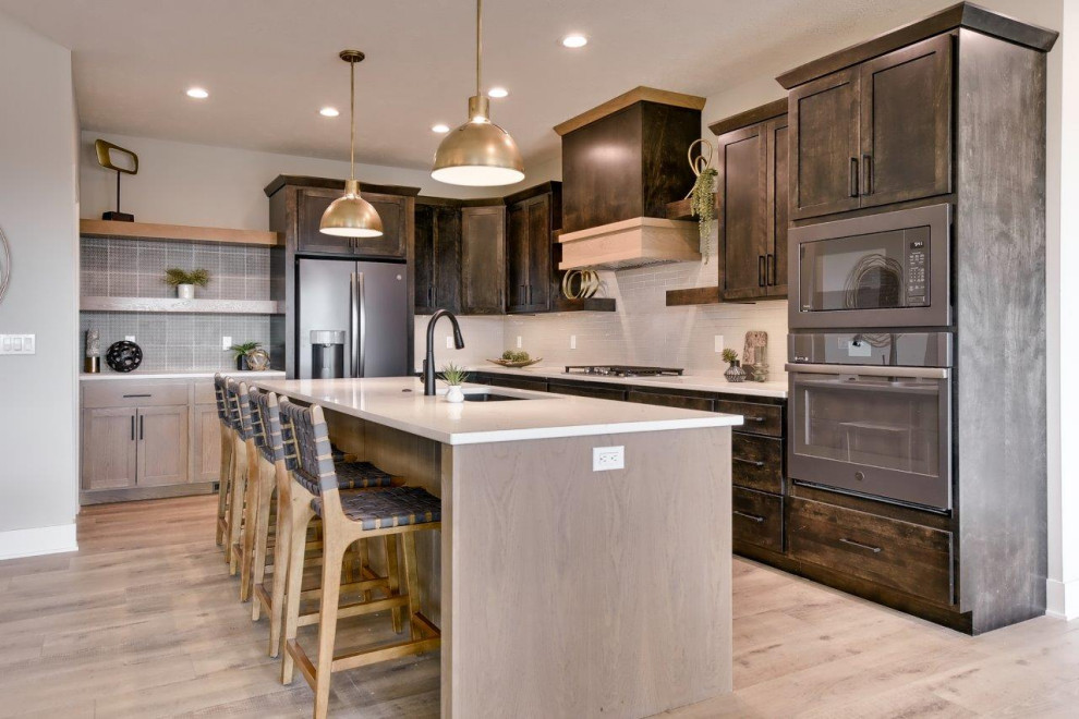 Transitional l-shaped open concept kitchen photo with shaker cabinets, white backsplash, an island and white countertops