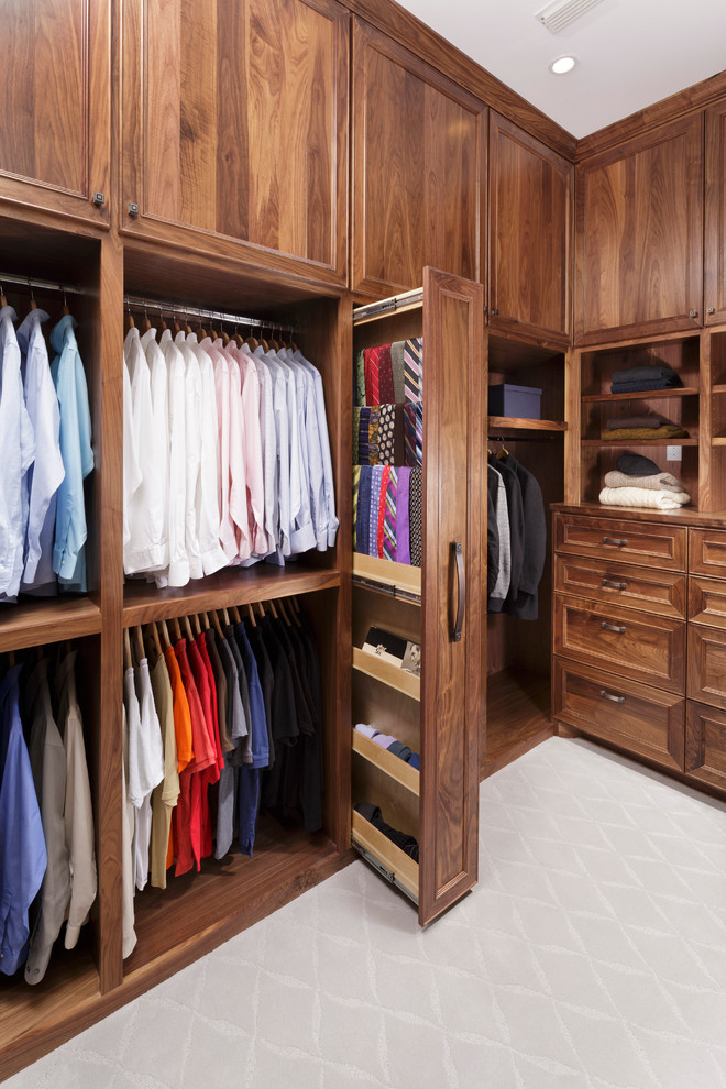 Design ideas for a traditional men's walk-in wardrobe in Houston with recessed-panel cabinets, dark wood cabinets and carpet.