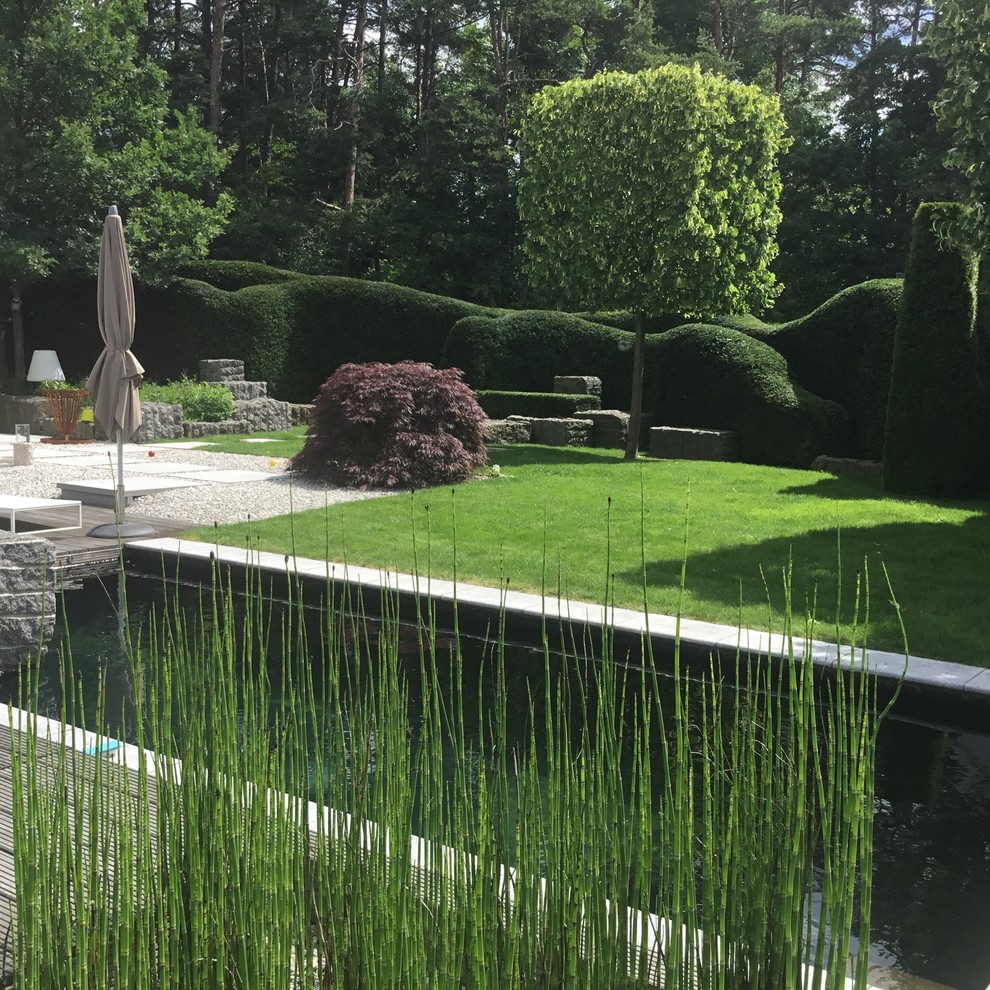 This is an example of a mid-sized asian side yard garden for summer in Nuremberg with a water feature and gravel.