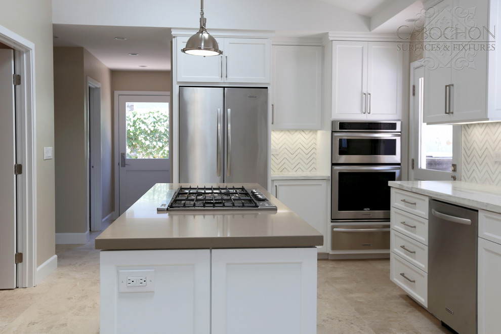Mid-sized transitional l-shaped limestone floor open concept kitchen photo in San Diego with an island, shaker cabinets, white cabinets, marble countertops, white backsplash, mosaic tile backsplash, stainless steel appliances, an undermount sink and beige walls