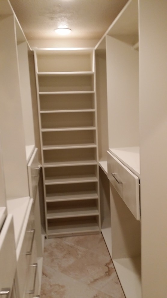 Inspiration for a small women's walk-in wardrobe in Houston with white cabinets, flat-panel cabinets, porcelain floors, beige floor and coffered.