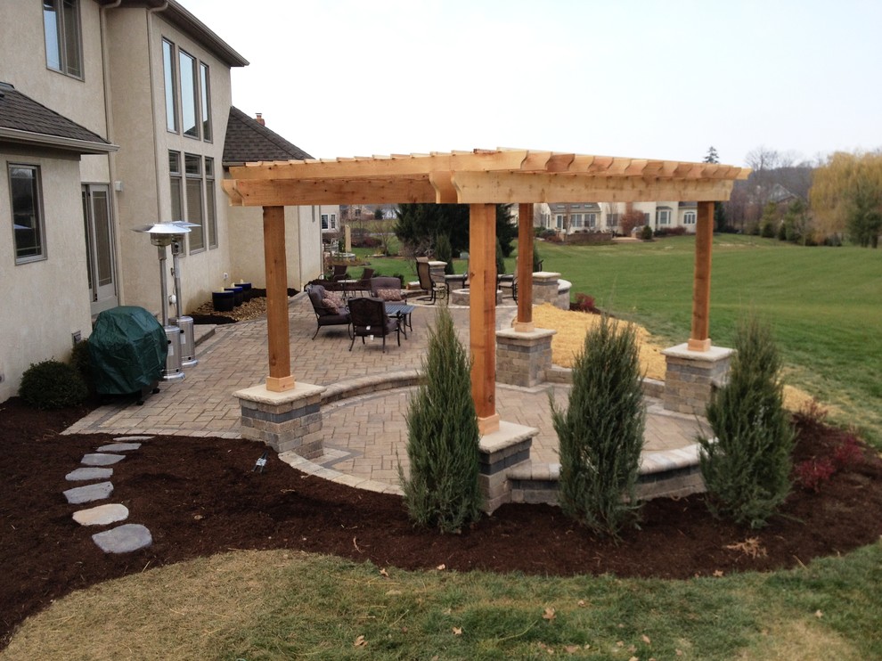 Inspiration for a large traditional patio in Columbus with brick pavers and a pergola.