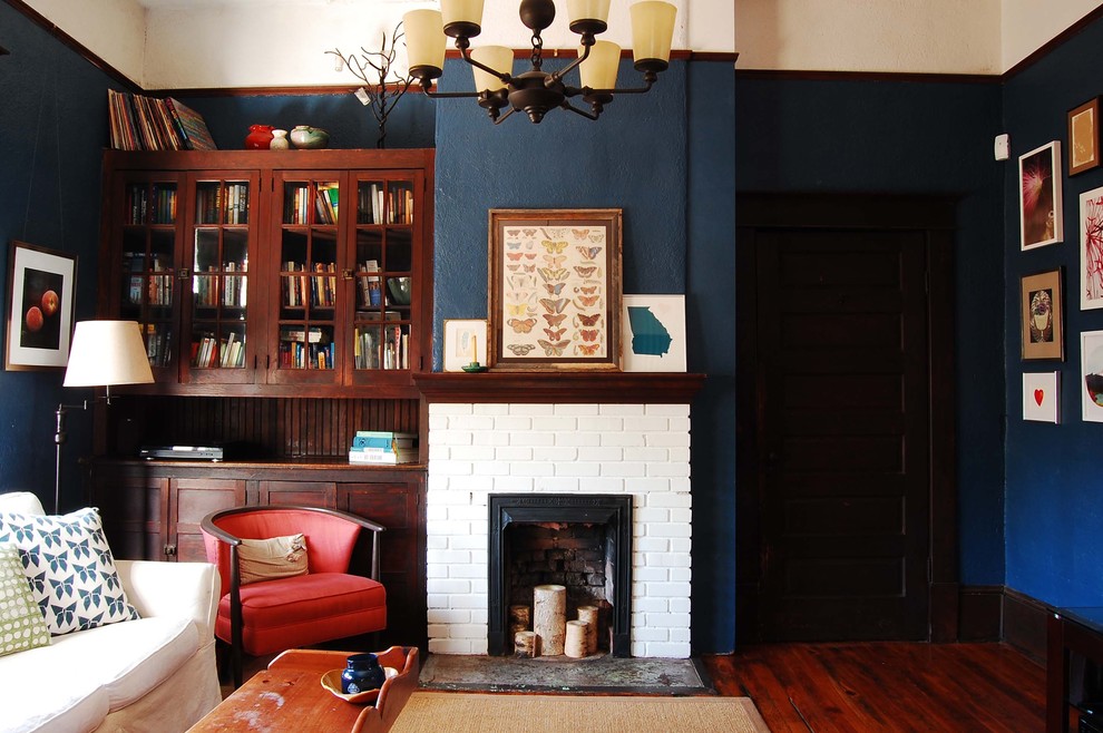 This is an example of a country living room in New York with blue walls, a standard fireplace and a brick fireplace surround.