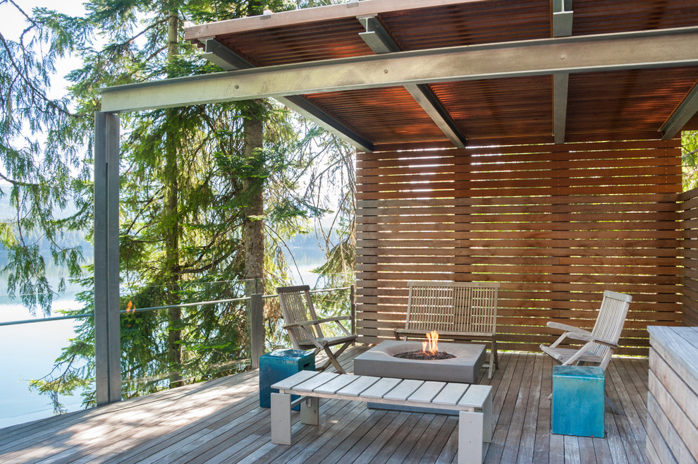 Mid-sized contemporary backyard deck in Seattle with a fire feature and an awning.