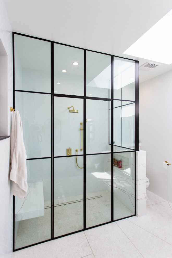 This is an example of a large master bathroom in Los Angeles with dark wood cabinets, a curbless shower, white tile, white walls, terrazzo floors, an integrated sink, marble benchtops, multi-coloured floor, white benchtops, a shower seat and a single vanity.