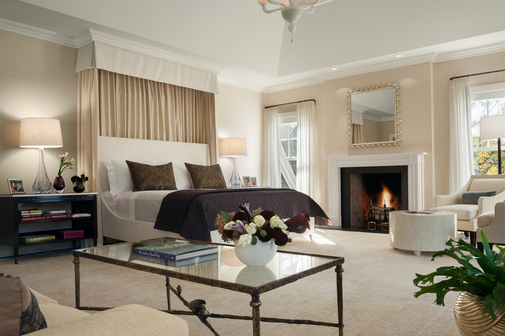 Photo of a mid-sized transitional master bedroom in New York with a standard fireplace, beige walls, a wood fireplace surround and carpet.