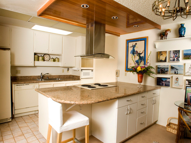 Mid-sized contemporary single-wall eat-in kitchen in San Francisco with a double-bowl sink, flat-panel cabinets, white cabinets, granite benchtops, brown splashback, stone slab splashback, white appliances, ceramic floors and with island.