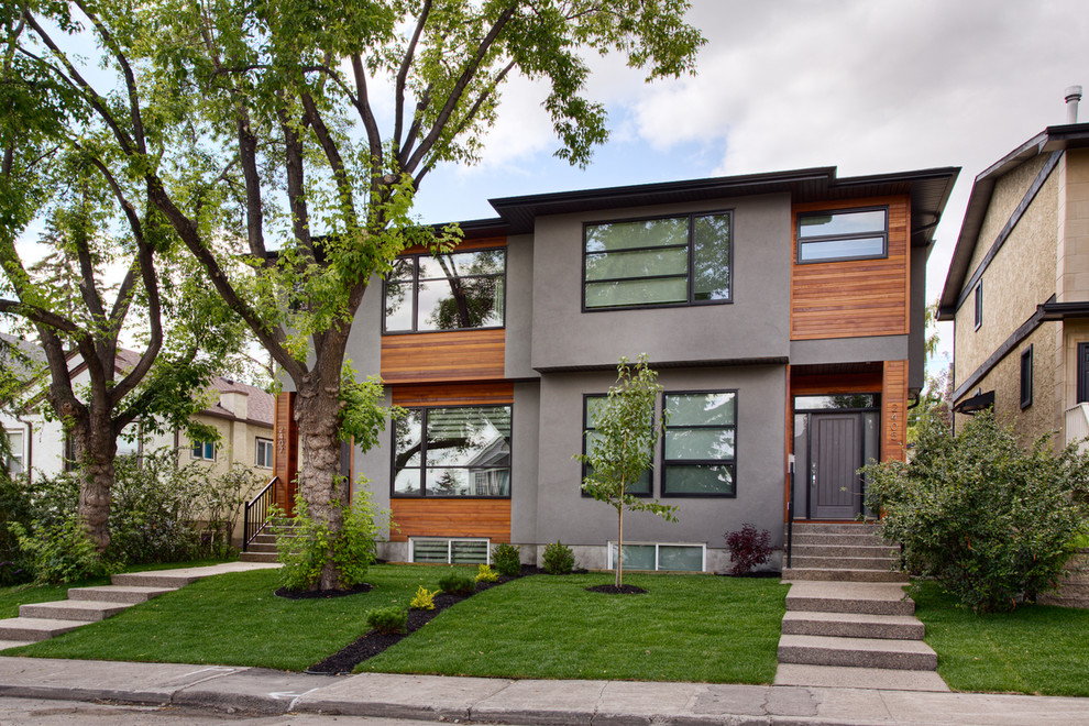 Inspiration for a contemporary duplex exterior in Calgary with wood siding.