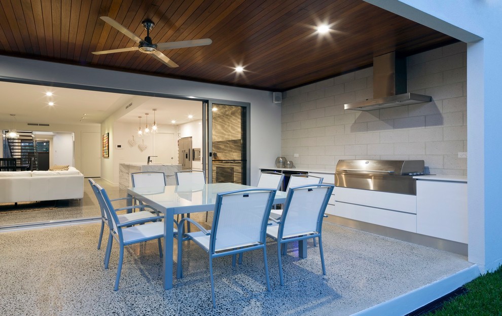 Contemporary backyard patio in Brisbane with an outdoor kitchen and a roof extension.