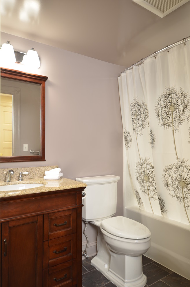 Small bathroom in Portland with furniture-like cabinets, medium wood cabinets, an alcove tub, a shower/bathtub combo, a two-piece toilet, purple walls, porcelain floors, an undermount sink and granite benchtops.