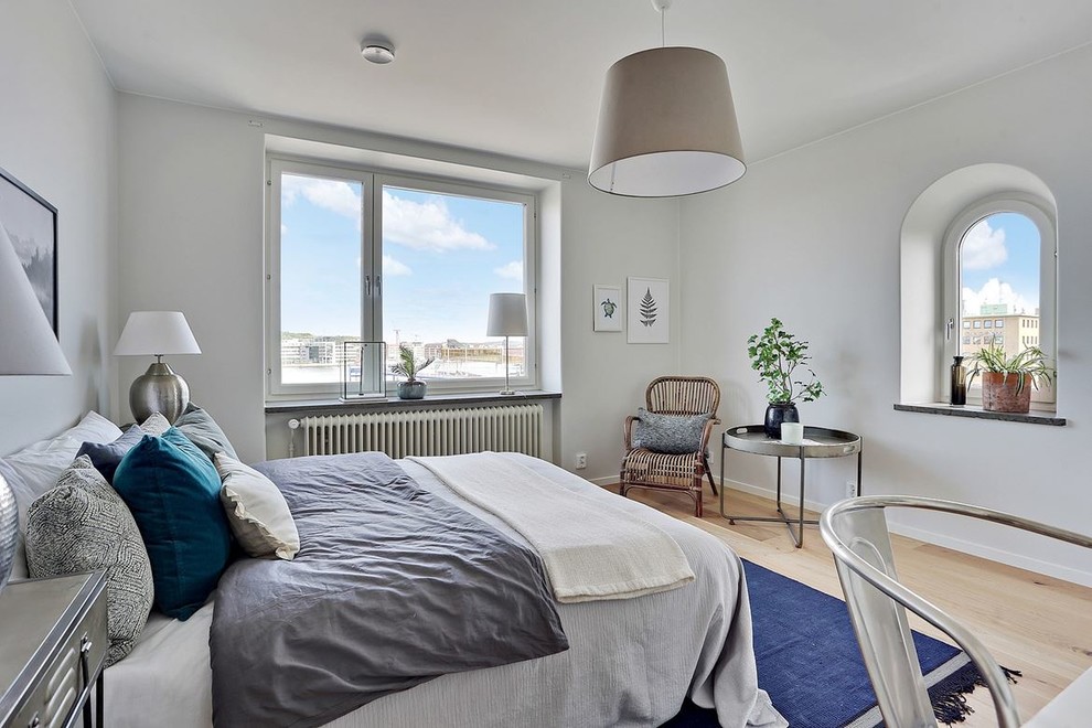 Mid-sized scandinavian master bedroom in Gothenburg with light hardwood floors and beige floor.