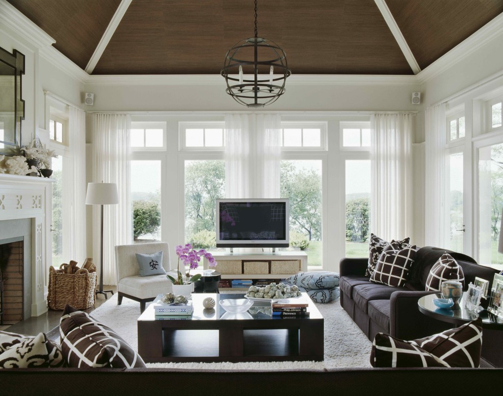 Inspiration for a traditional family room in New York with white walls, a standard fireplace and a freestanding tv.