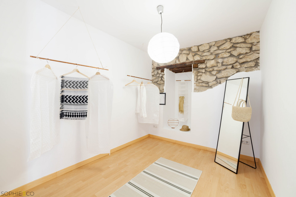 This is an example of a large scandinavian gender-neutral dressing room in Other with laminate floors and brown floor.