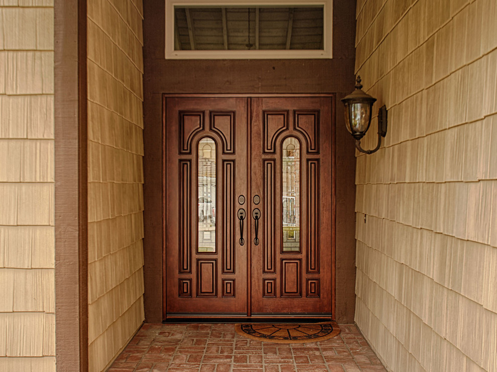 Expansive traditional front door in Orange County with brown walls, a double front door and a dark wood front door.