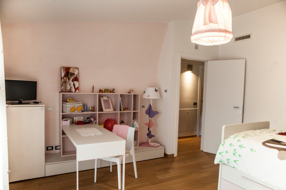 Inspiration for an expansive modern kids' bedroom for kids 4-10 years old and girls in Other with pink walls and medium hardwood floors.