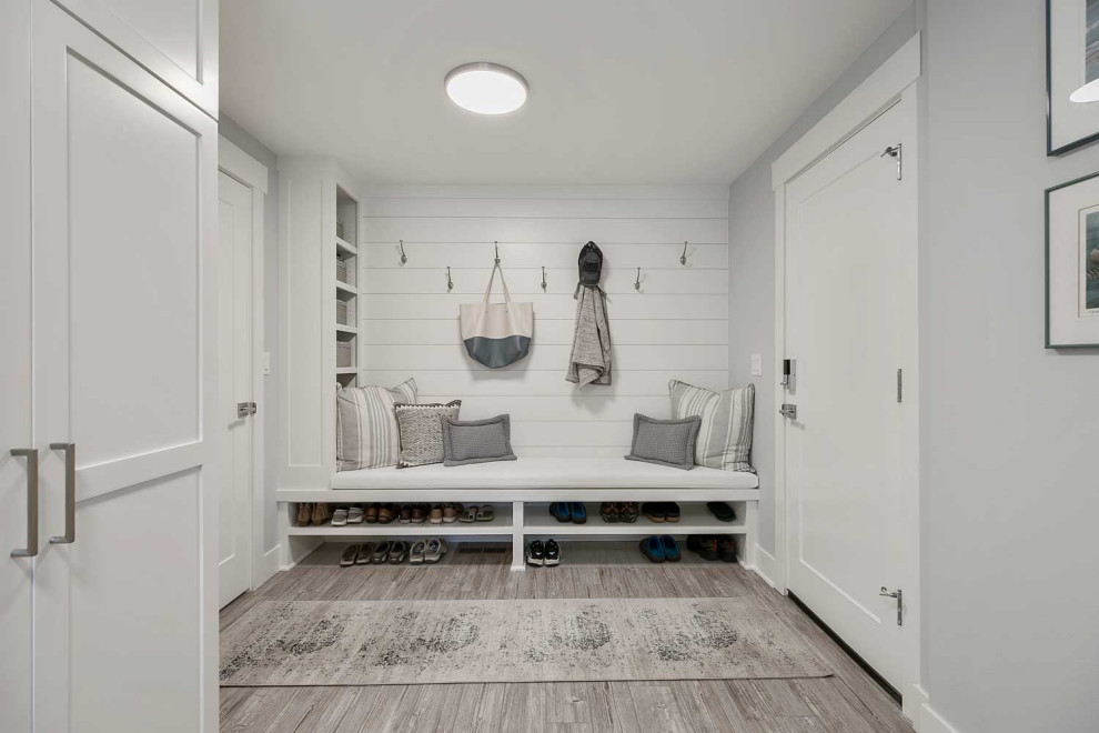 Mid-sized beach style l-shaped utility room in Portland with an undermount sink, shaker cabinets, white cabinets, quartz benchtops, grey splashback, vinyl floors, a stacked washer and dryer, grey floor, white benchtop and planked wall panelling.