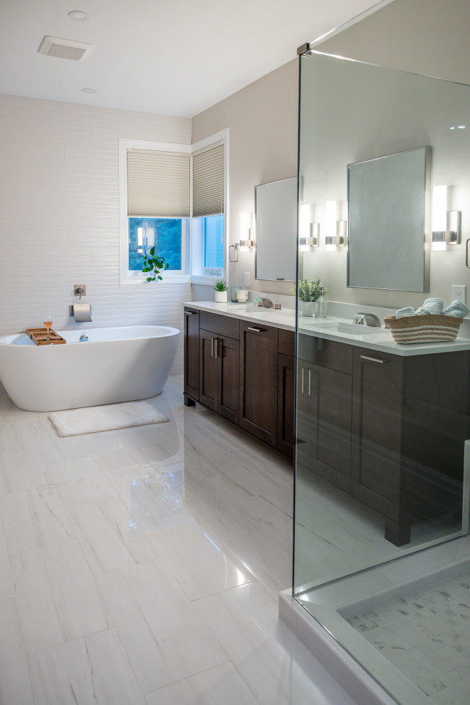 Inspiration for a contemporary master bathroom in Seattle with furniture-like cabinets, dark wood cabinets, a freestanding tub, a corner shower, a one-piece toilet, white tile, ceramic tile, white walls, ceramic floors, an undermount sink, marble benchtops, white floor, a hinged shower door, white benchtops, a shower seat, a double vanity and a freestanding vanity.