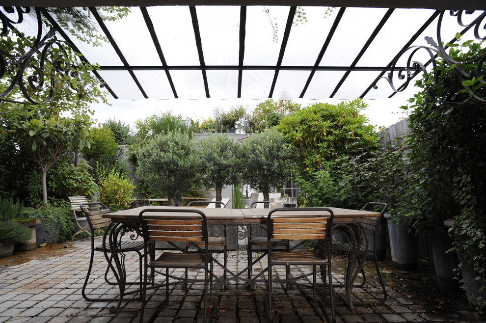 Idée de décoration pour une grande terrasse arrière tradition avec des pavés en béton et une pergola.