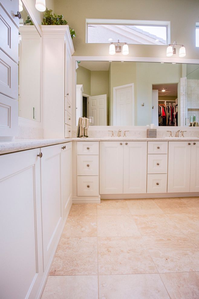 Photo of a large transitional master bathroom in Phoenix with recessed-panel cabinets, white cabinets, a corner shower, beige tile, travertine, green walls, travertine floors, an undermount sink and granite benchtops.