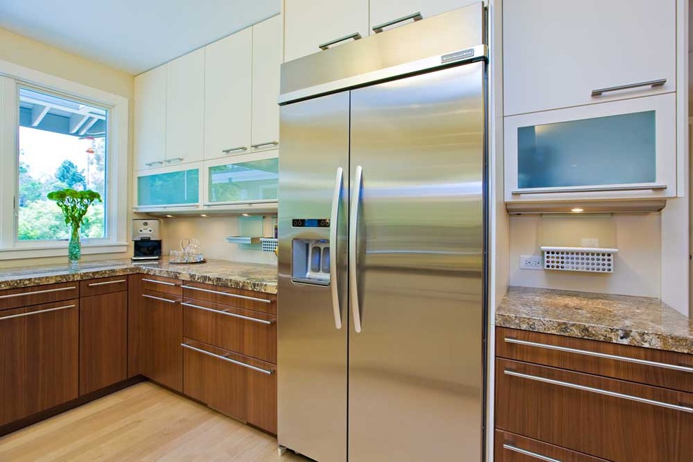 Large contemporary u-shaped open plan kitchen in San Francisco with an undermount sink, flat-panel cabinets, granite benchtops, white splashback, stainless steel appliances, light hardwood floors, white cabinets, with island, beige floor and multi-coloured benchtop.