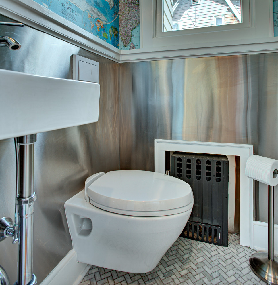 This is an example of a small eclectic powder room in New York with a wall-mount sink, a wall-mount toilet, multi-coloured walls and marble floors.