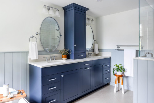 Elegant bathroom cabinets in navy blue with dual sinks, white countertop, and modern storage design