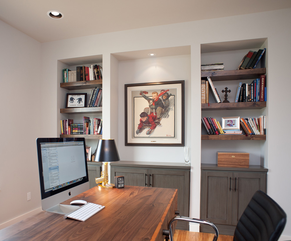 Photo of a mid-sized contemporary study room in Oklahoma City with white walls, light hardwood floors, no fireplace and a freestanding desk.