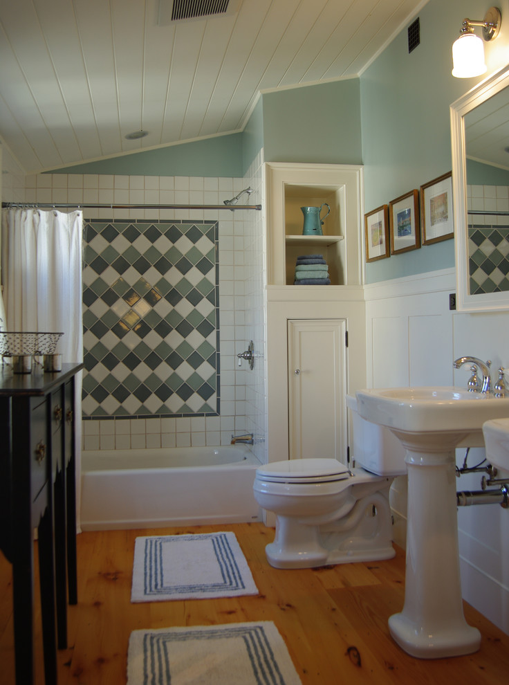 Kids bathroom in Boston with recessed-panel cabinets, white cabinets, a drop-in tub, a shower/bathtub combo, a two-piece toilet, green tile, porcelain tile, green walls, medium hardwood floors and a pedestal sink.