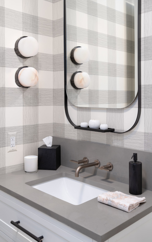 Design ideas for a mid-sized powder room in Detroit with flat-panel cabinets, white cabinets, marble benchtops, a freestanding vanity and wallpaper.