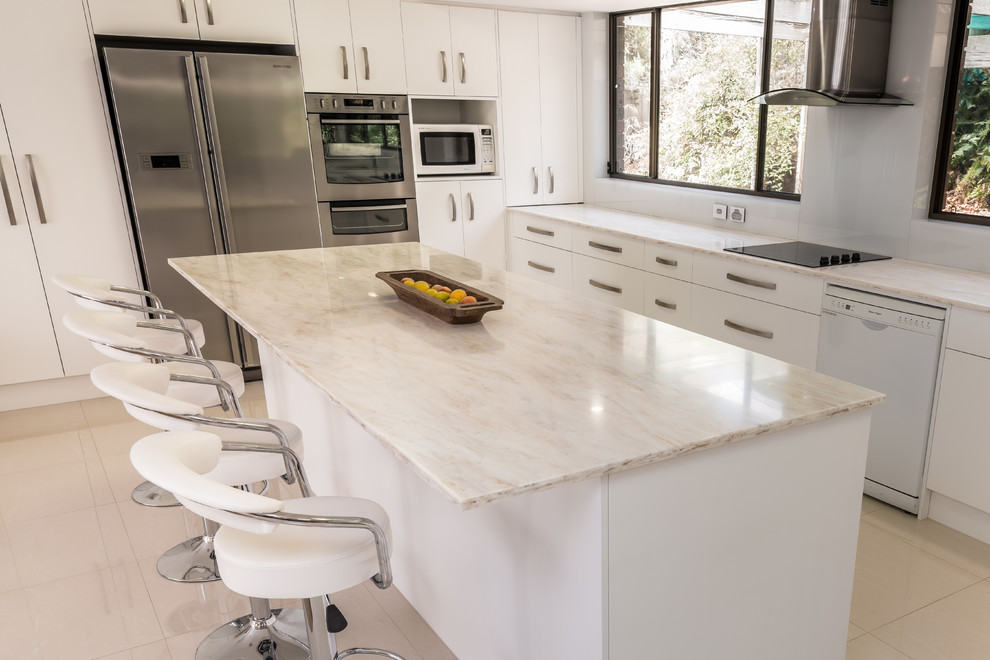 Photo of a large contemporary eat-in kitchen in Other with an undermount sink, white cabinets, solid surface benchtops, white splashback, glass sheet splashback, stainless steel appliances, porcelain floors and with island.