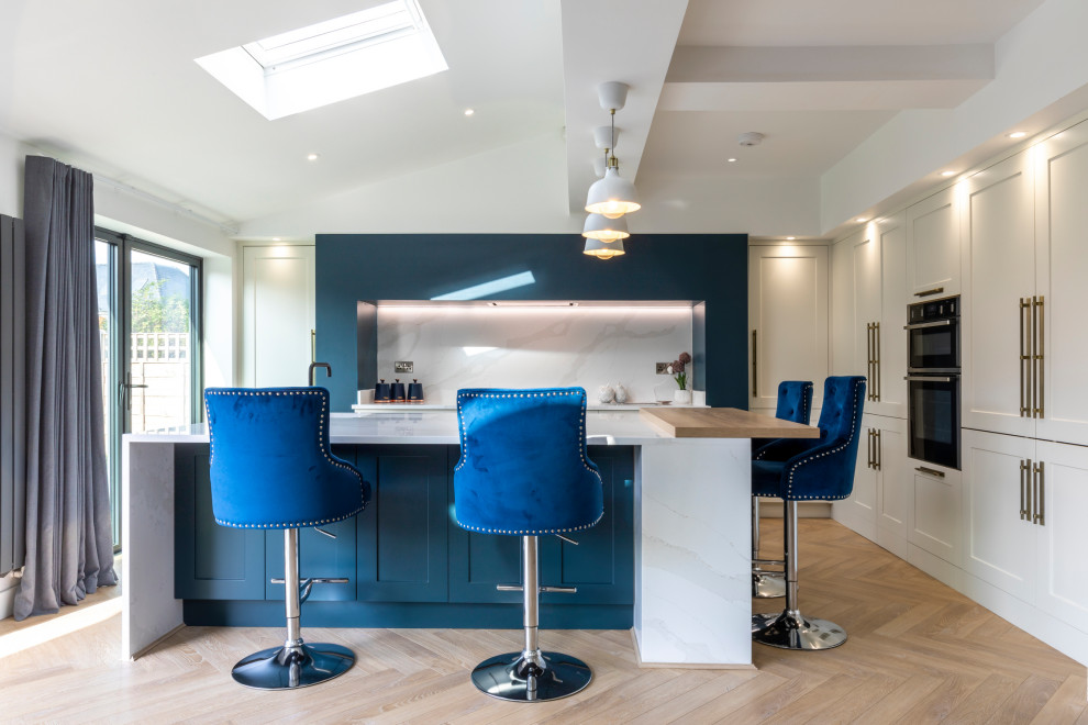 Immagine di un grande cucina con isola centrale moderno con lavello integrato, ante in stile shaker, ante blu, top in quarzite e elettrodomestici da incasso