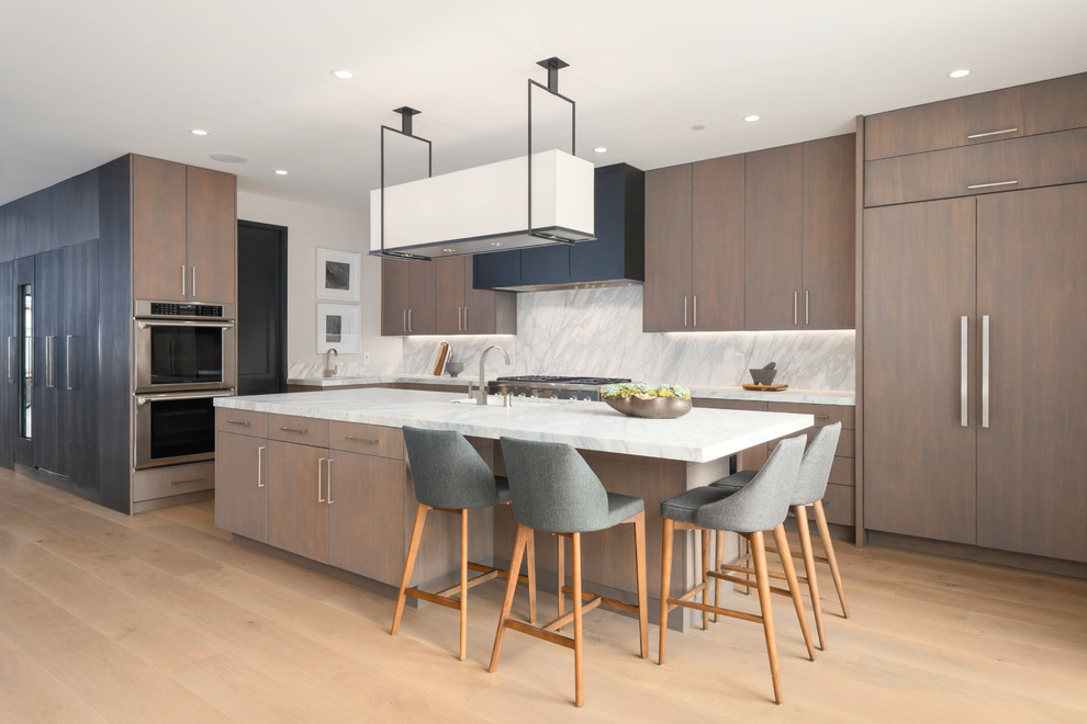 Design ideas for a modern galley open plan kitchen in San Francisco with shaker cabinets, dark wood cabinets, grey splashback, stainless steel appliances, light hardwood floors, with island and brown floor.