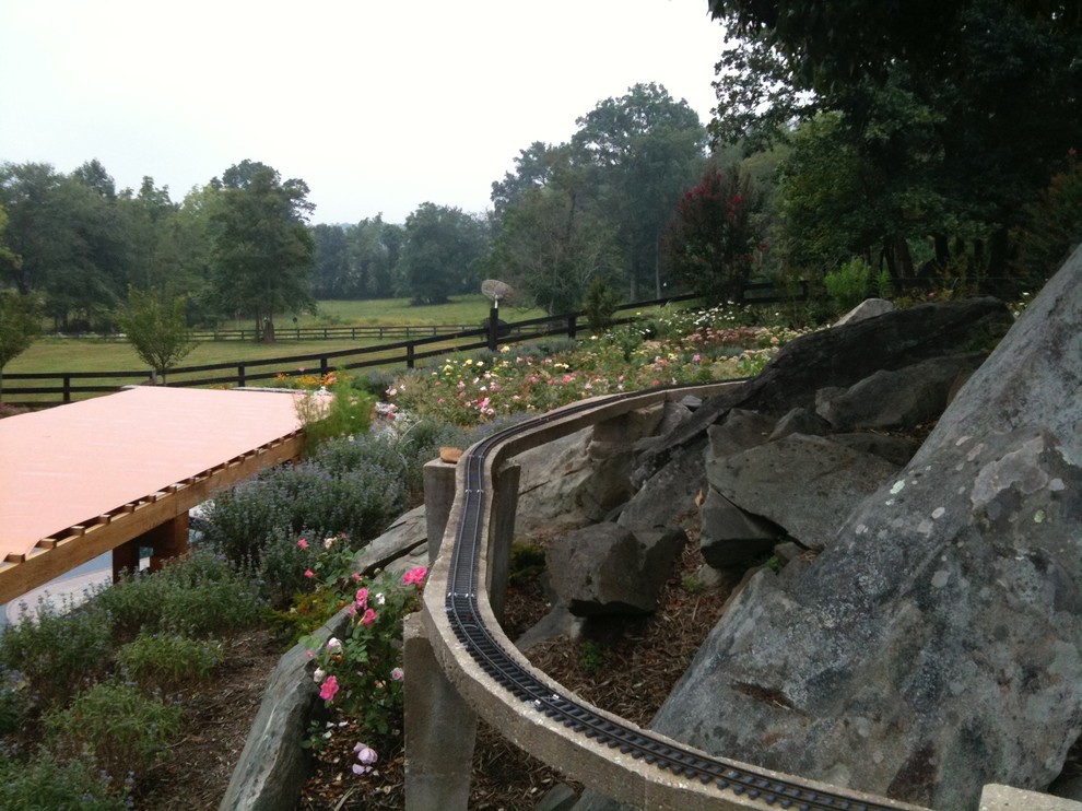 Photo of a large rustic partial sun backyard stone formal garden for summer.