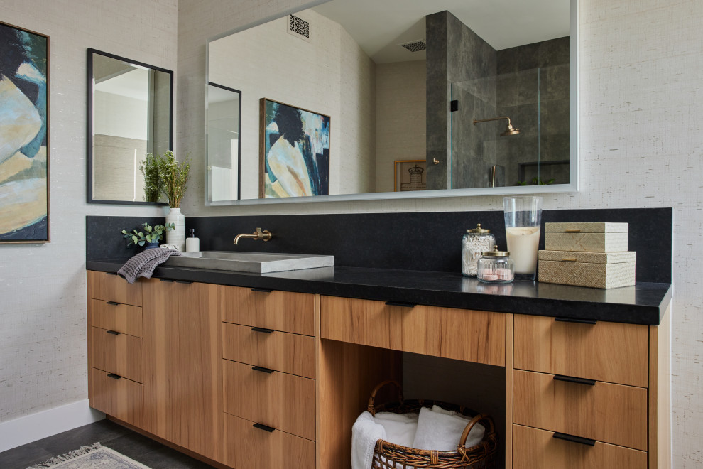 Inspiration for a transitional bathroom in Los Angeles with flat-panel cabinets, medium wood cabinets, black tile, porcelain tile, porcelain floors, black floor, black benchtops, a single vanity, a built-in vanity and wallpaper.