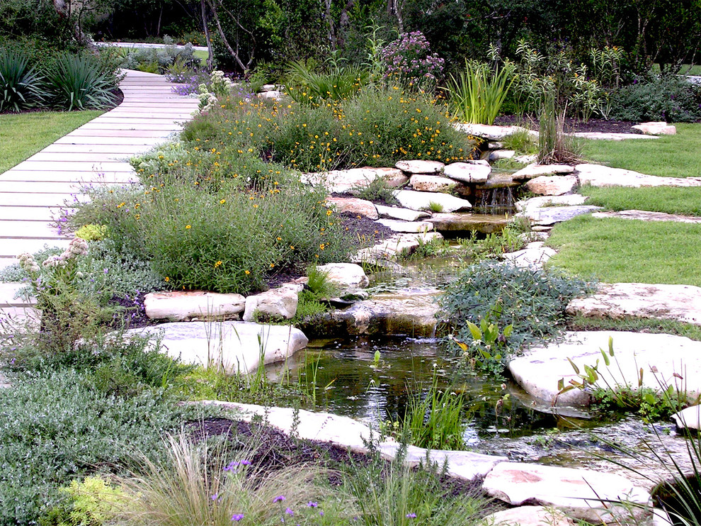 Design ideas for a mid-sized traditional backyard partial sun formal garden in Austin with with pond and decking.