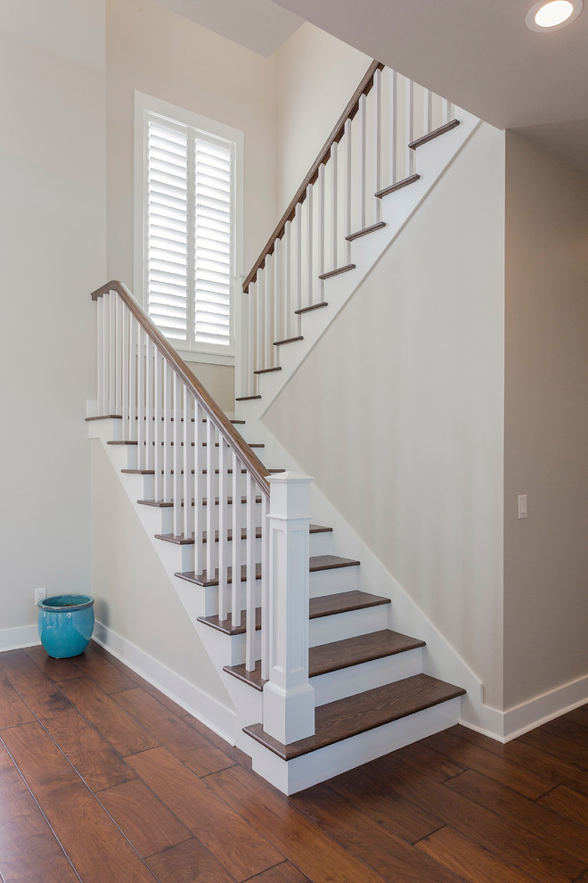 This is an example of a transitional u-shaped staircase in Tampa with wood risers and wood railing.