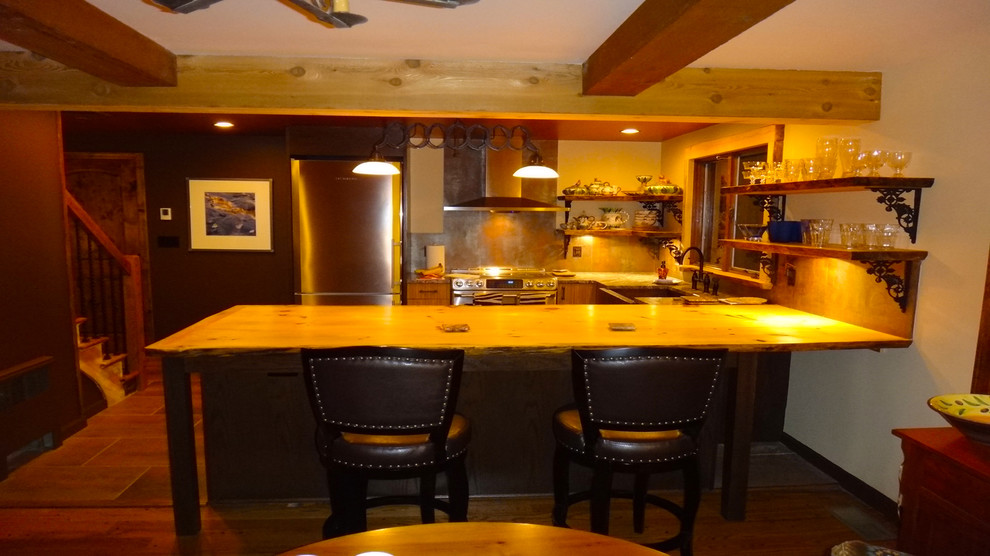 Mid-sized mountain style kitchen photo with medium tone wood cabinets, wood countertops, metallic backsplash and an island