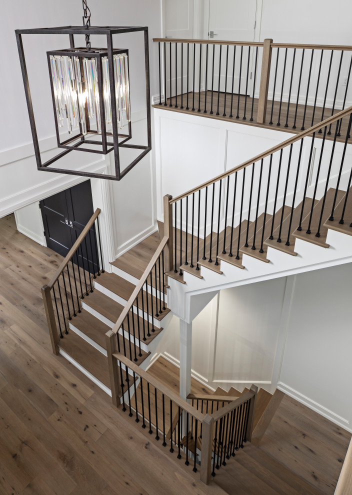 Inspiration for an expansive modern wood u-shaped staircase in Detroit with wood risers, mixed railing and decorative wall panelling.