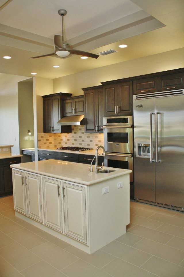 Eat-in kitchen - large transitional u-shaped porcelain tile eat-in kitchen idea in Phoenix with an undermount sink, raised-panel cabinets, dark wood cabinets, quartz countertops, beige backsplash, stone tile backsplash, stainless steel appliances and an island