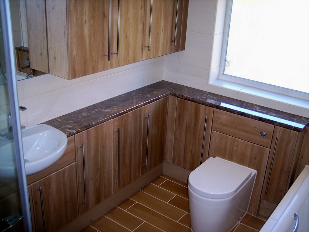 Small bathroom in Essex with flat-panel cabinets, brown cabinets, a built-in bath, beige tiles, porcelain tiles, porcelain flooring, a vessel sink, laminate worktops, beige floors and a hinged door.