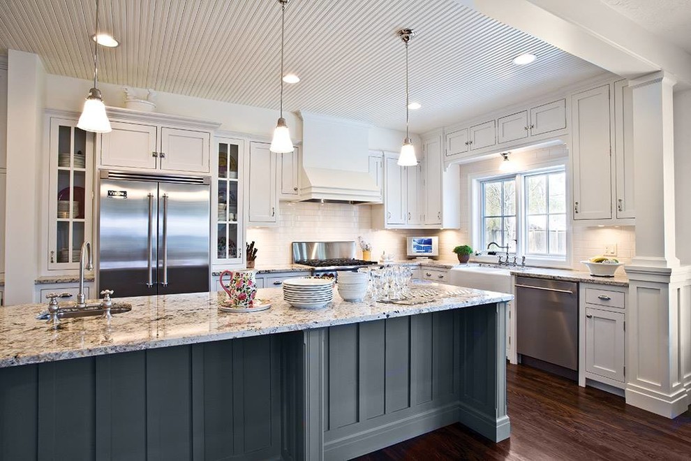 Inspiration for a mid-sized transitional l-shaped dark wood floor and brown floor eat-in kitchen remodel in Baltimore with a farmhouse sink, shaker cabinets, white cabinets, granite countertops, gray backsplash, porcelain backsplash, stainless steel appliances and an island