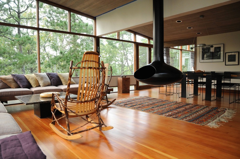 Midcentury open concept living room in Boston with a hanging fireplace.