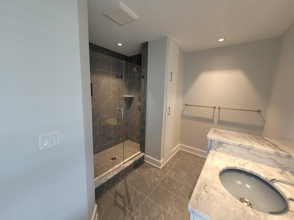 Small trendy master gray tile and stone tile slate floor, gray floor and double-sink alcove shower photo in Baltimore with recessed-panel cabinets, white cabinets, a two-piece toilet, gray walls, an undermount sink, marble countertops, a hinged shower door, white countertops and a built-in vanity