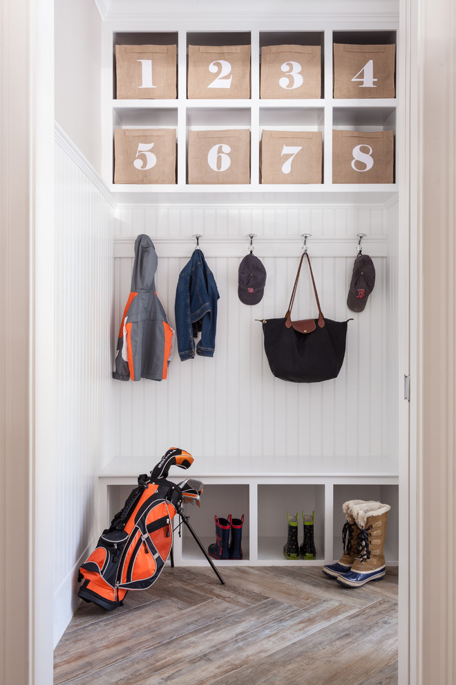This is an example of a transitional mudroom in Boston with white walls.