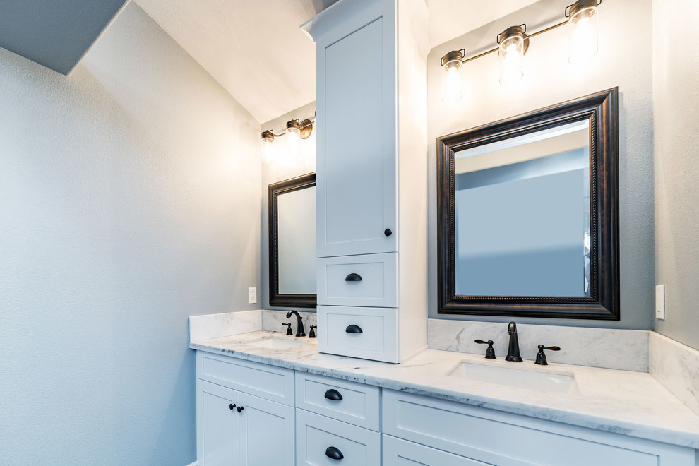 This is an example of a mid-sized transitional master bathroom in Other with shaker cabinets, white cabinets, an alcove tub, a shower/bathtub combo, a two-piece toilet, white tile, marble, grey walls, dark hardwood floors, an undermount sink, marble benchtops, brown floor and a shower curtain.