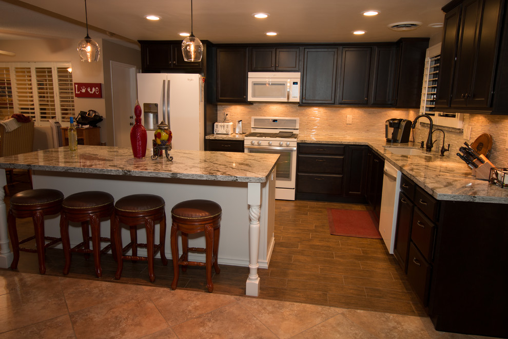 Mid-sized transitional l-shaped porcelain tile open concept kitchen photo with an undermount sink, flat-panel cabinets, dark wood cabinets, quartz countertops, beige backsplash, glass sheet backsplash, white appliances and an island