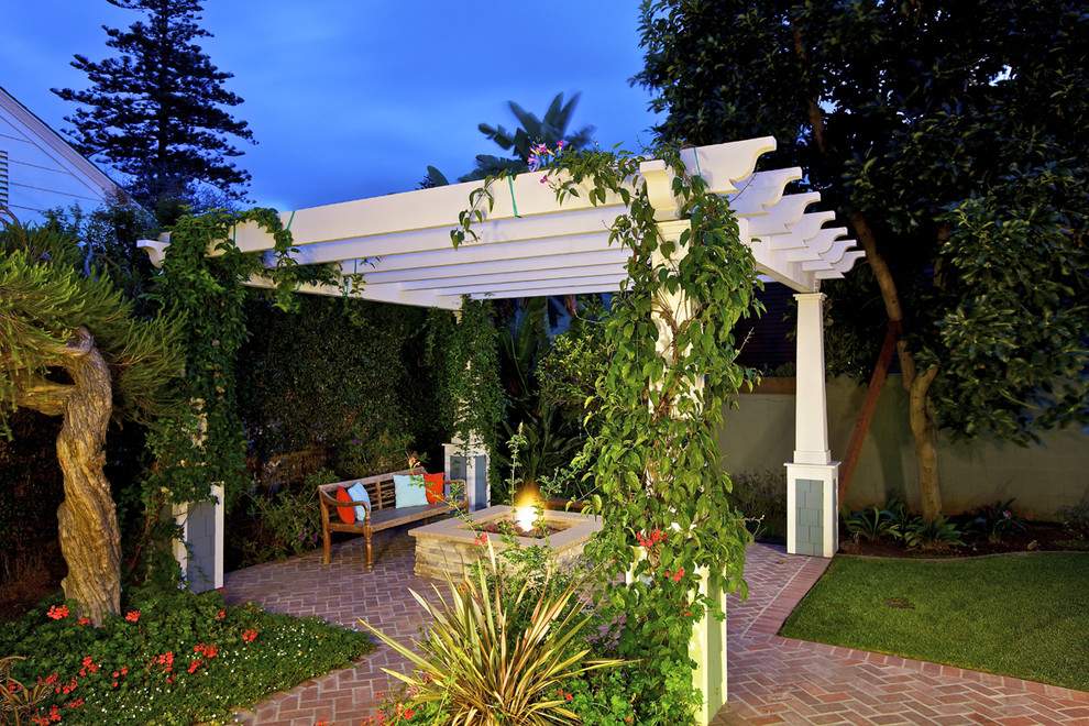 This is an example of a traditional patio in San Diego with a fire feature and a gazebo/cabana.