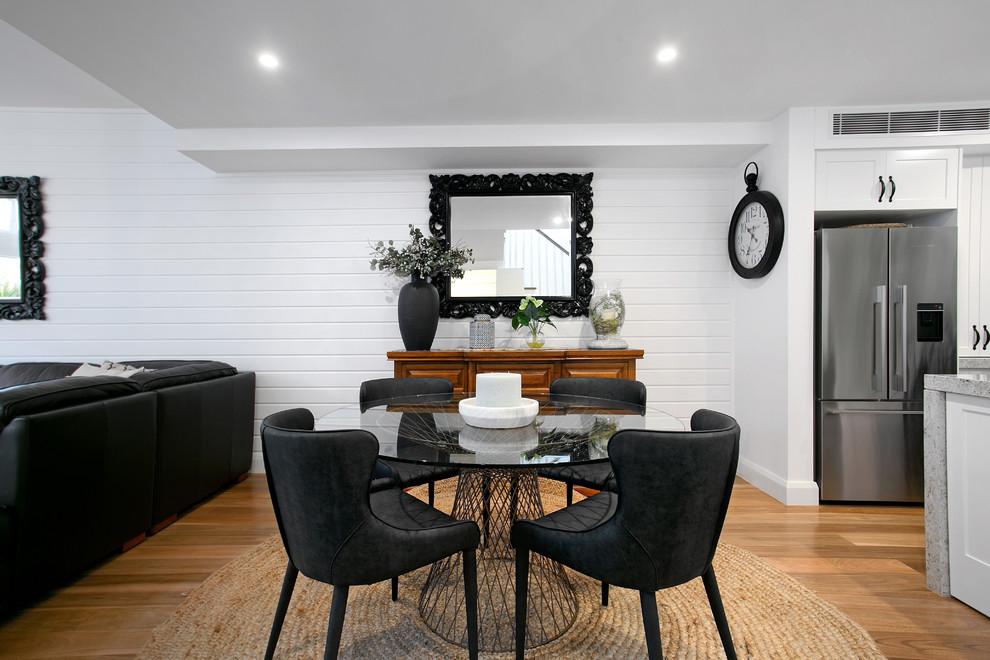 Scandinavian open plan dining in Sydney with white walls, light hardwood floors and no fireplace.