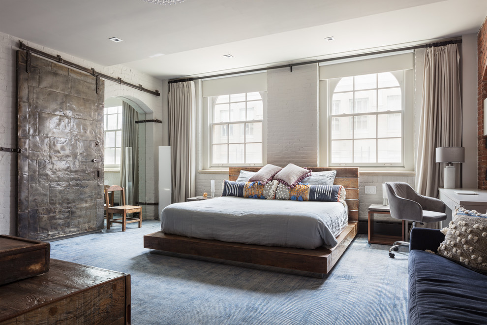 Design ideas for an industrial bedroom in New York with white walls, carpet and blue floor.